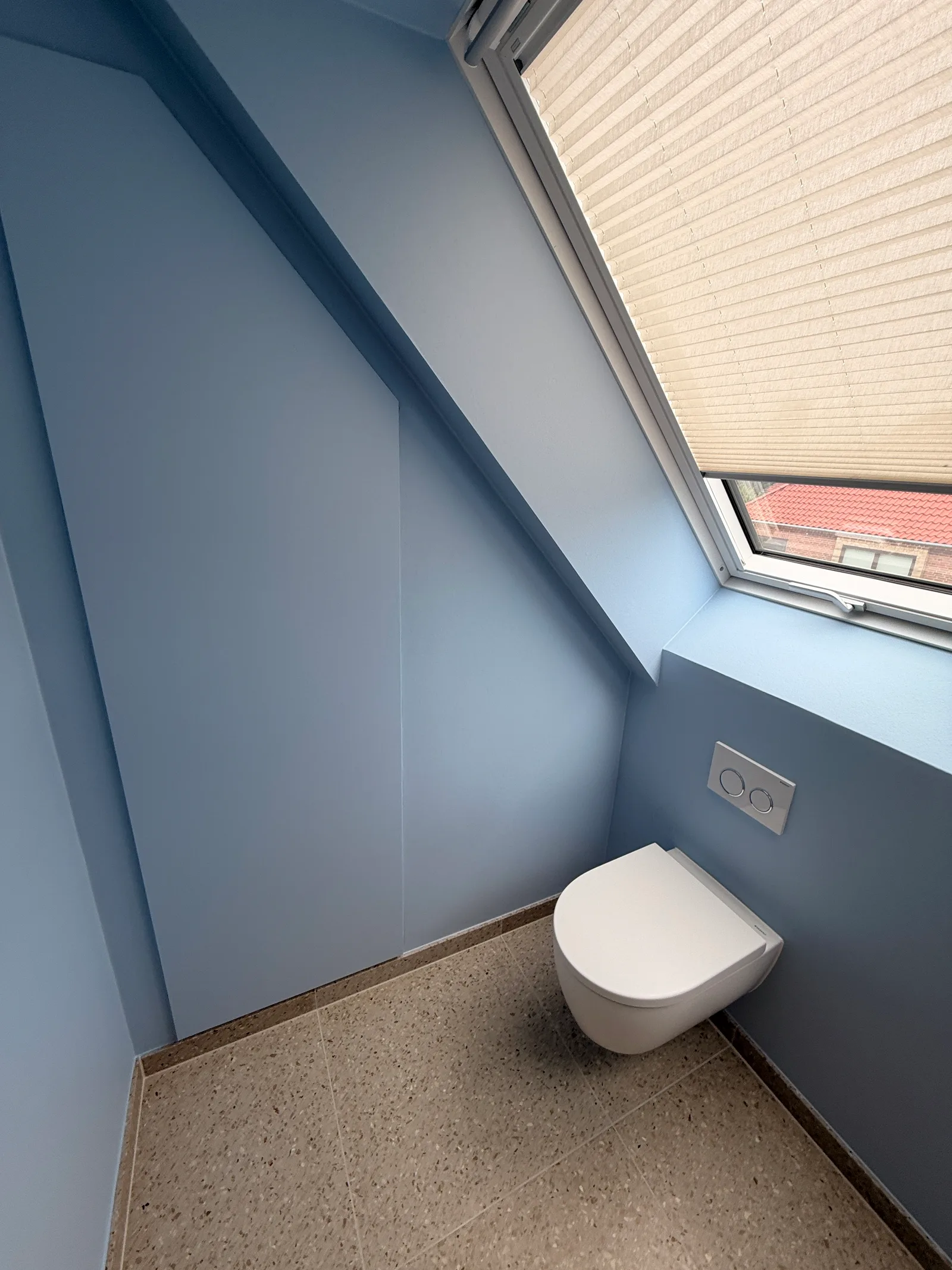 Ny 1. sal Brønshøj — toilet med væghængt toilet, lyseblå vægge og ovenlys med plisségardin