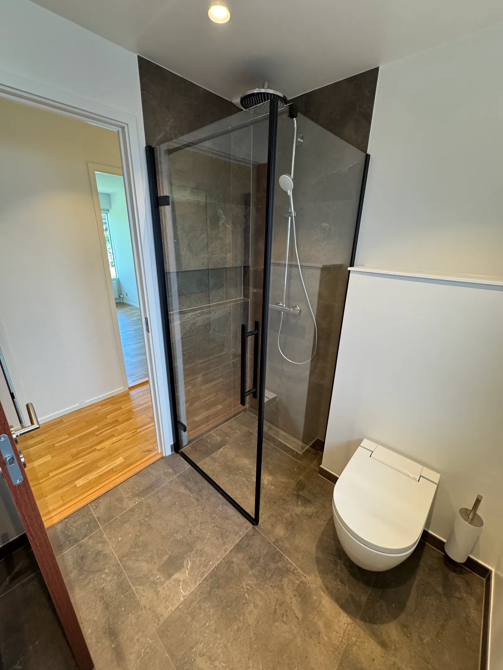 Klintevej Allerød — nyt badeværelse med walk-in brus bag glas, grå natursten-klinker og vægophængt toilet