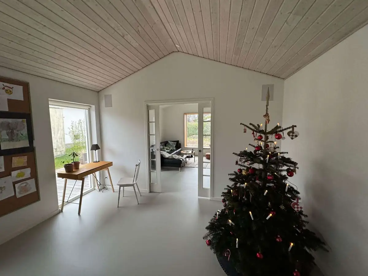 Tilbygning Ballerup — renoveret stue med vaulted wood-loft og juletræ